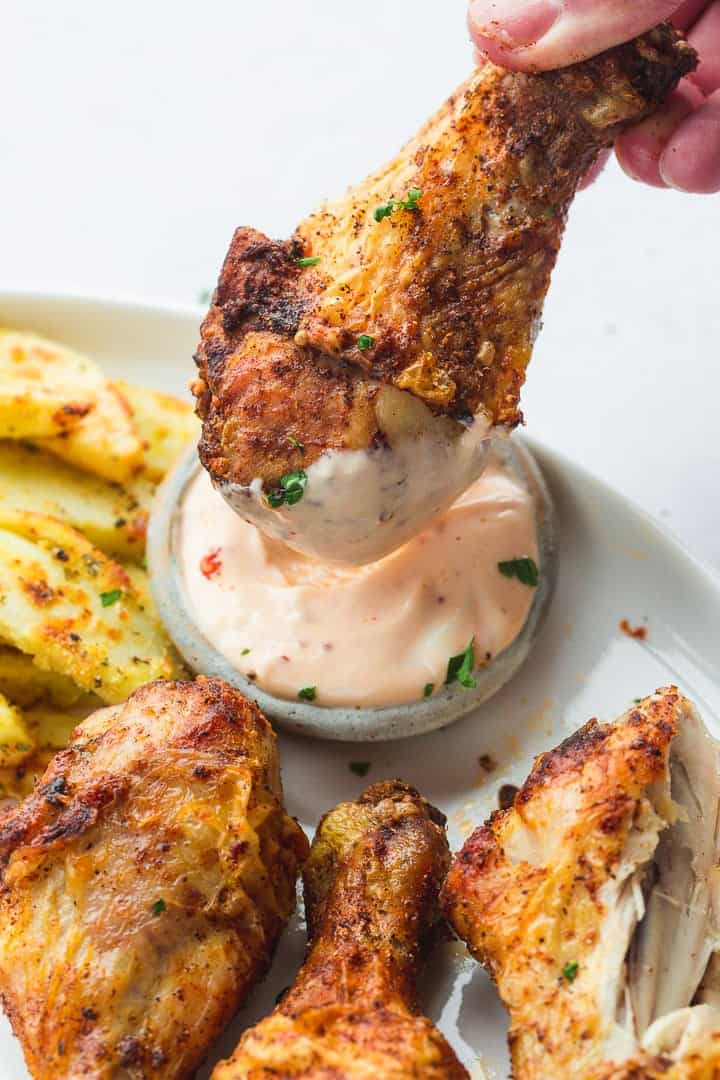 Dipping a baked drumstick in sweet chilli mayo dip.