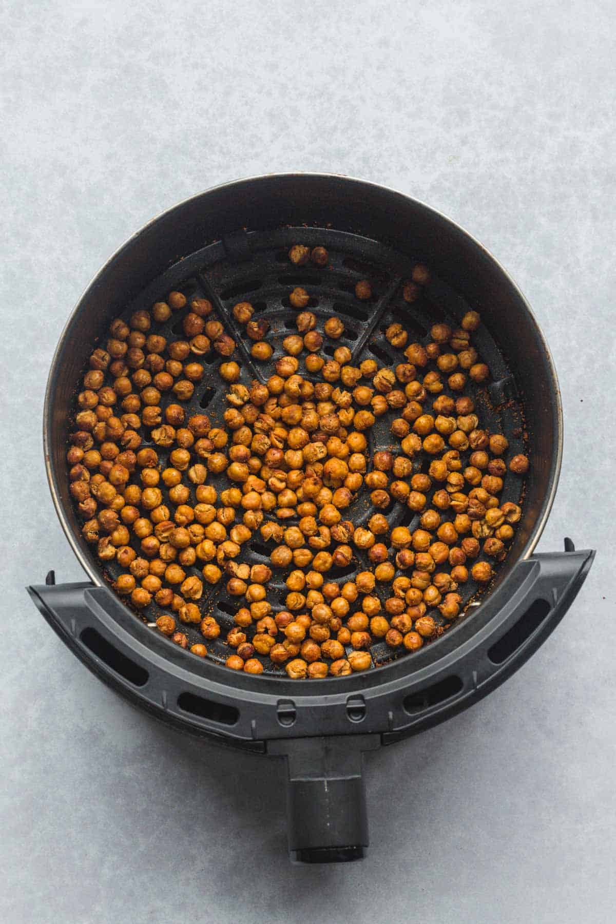 Roasted chickpeas (after air frying) in an air fryer basket. 