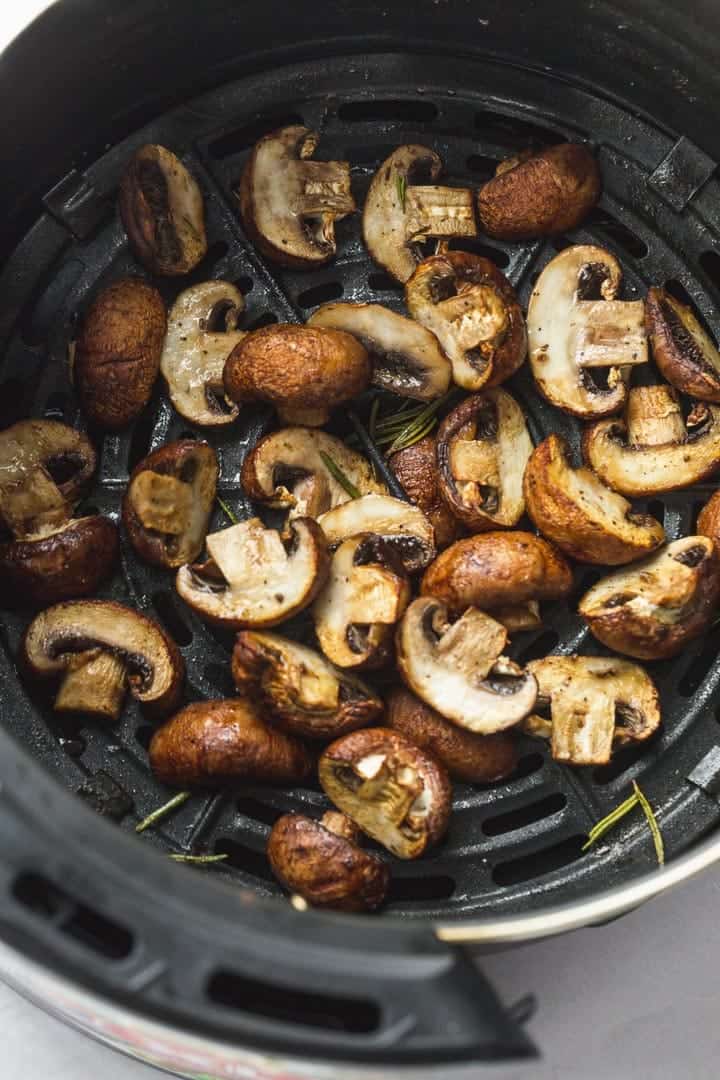 Cooked mushrooms in an air fryer basket.