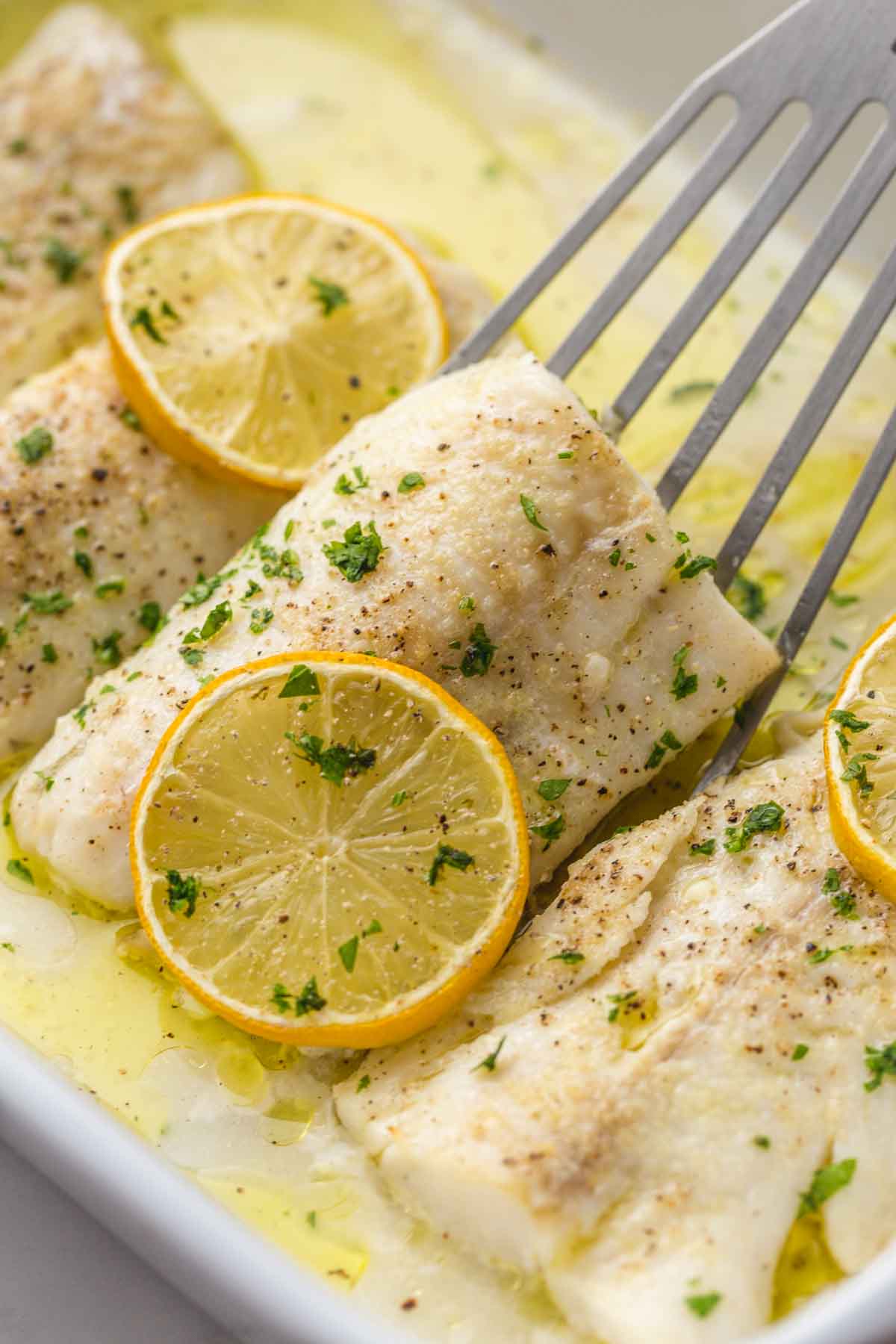 Serving baked cod with lemon with a fish spatula
