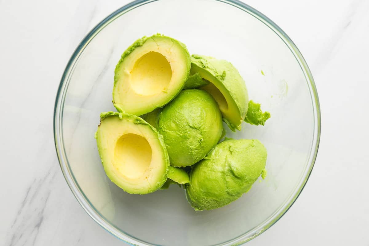 Sliced avocado halves in a glass bowl