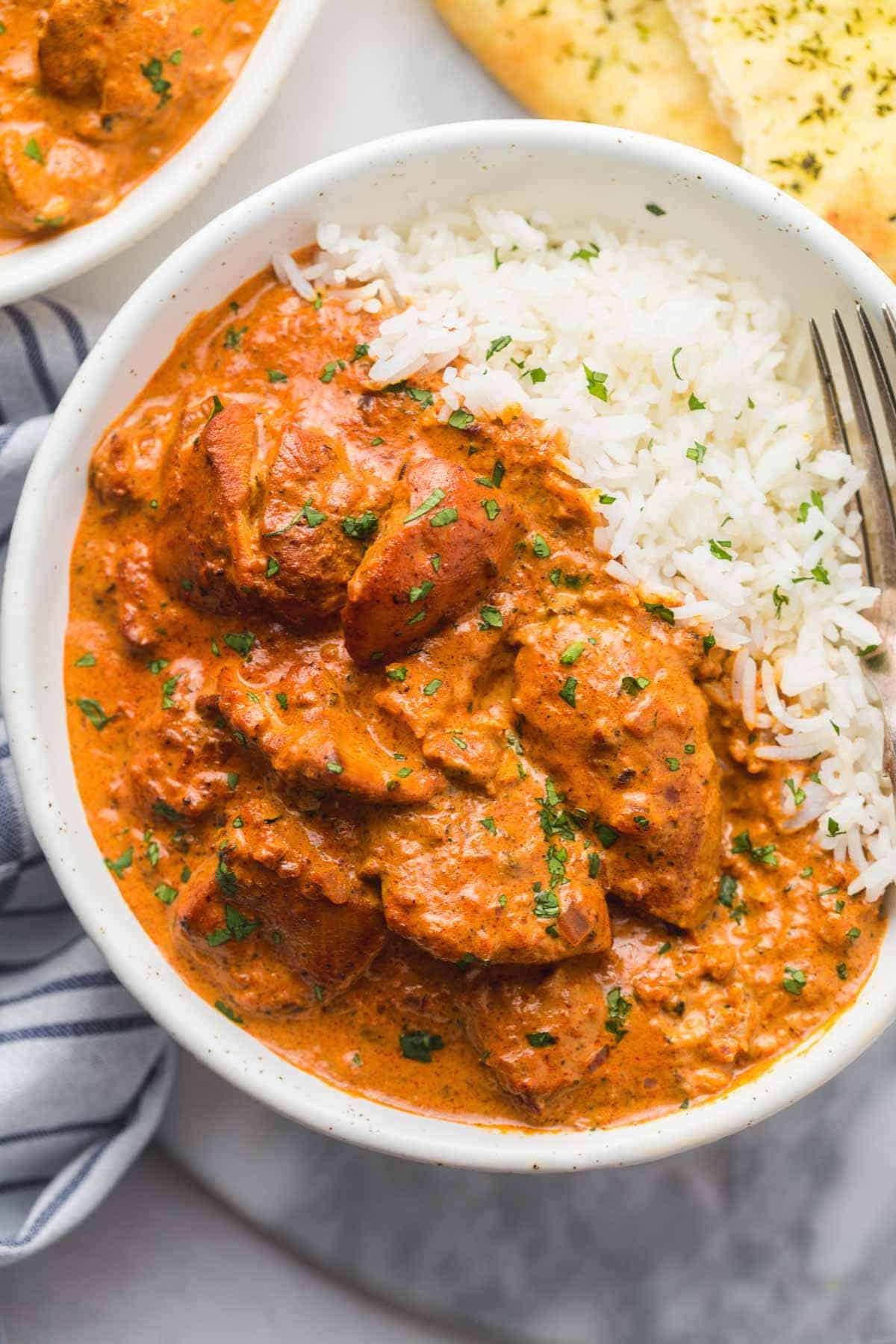 Chicken tikka masala served with basmati rice in a bowl