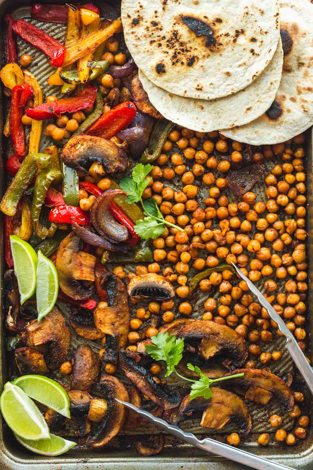 Chickpea Fajitas on a sheet pan with tortilla bread, and lime wedges
