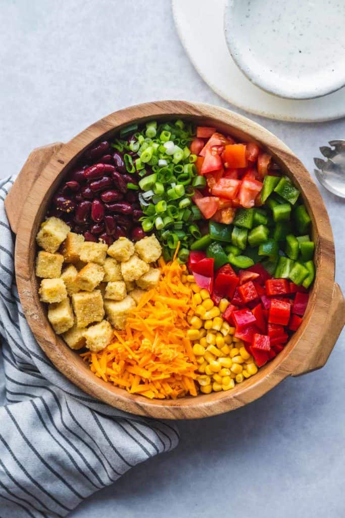 The ingredients of the cornbread salad in a wooden bowl
