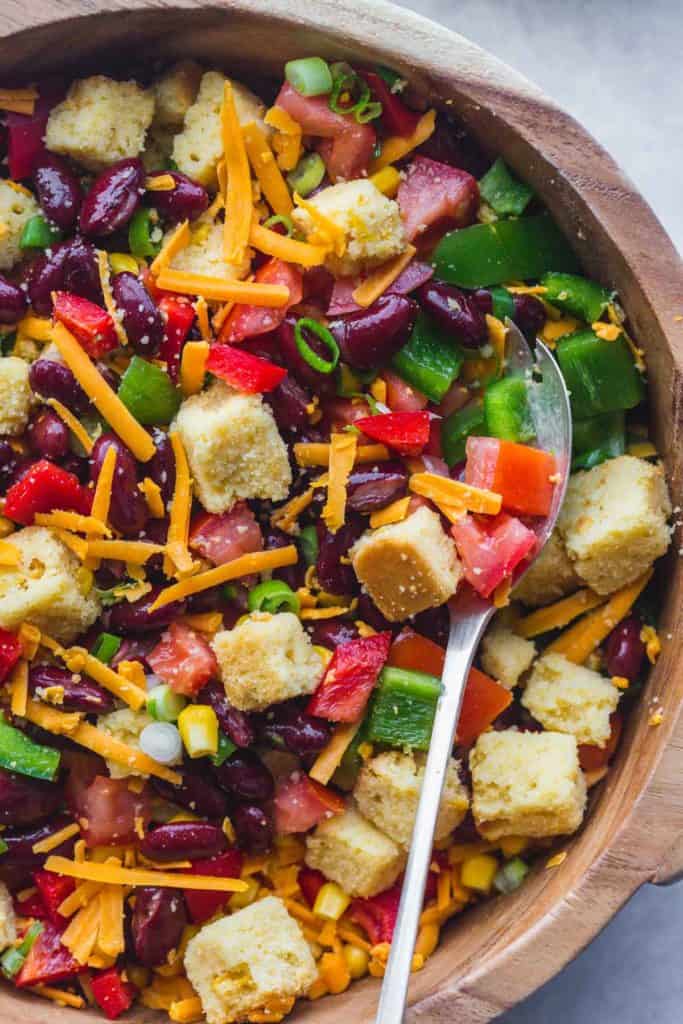 A close up image of cornbread salad with a fork before adding the dressing