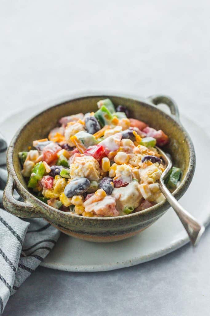 Cornbread salad in a clay bowl with a fork