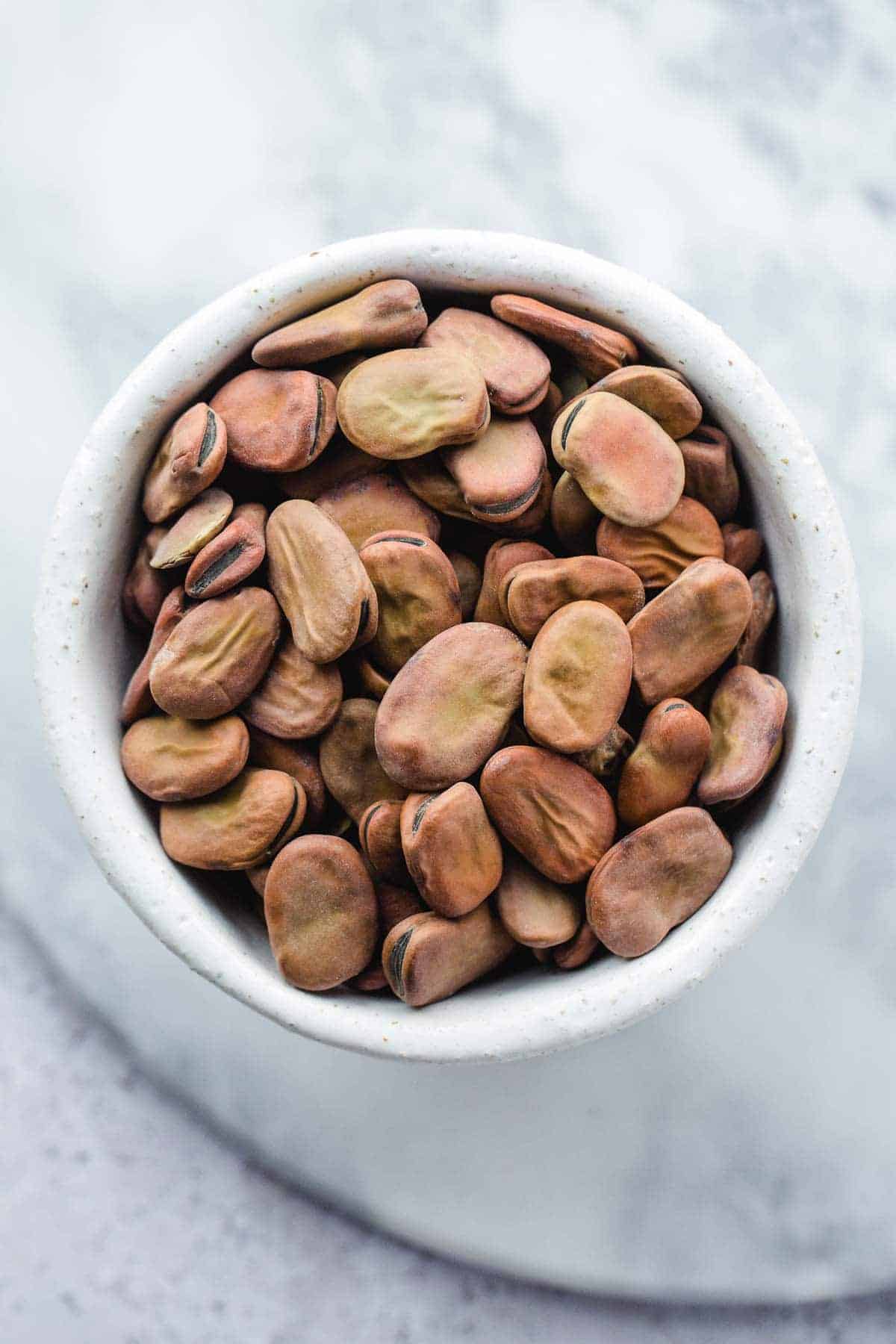 Dried broad beans in a white bowl