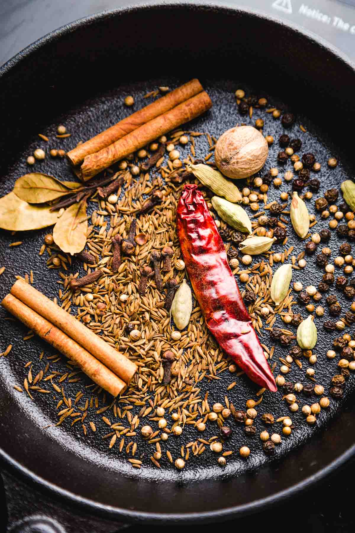 Toasting the whole spices on a black skillet