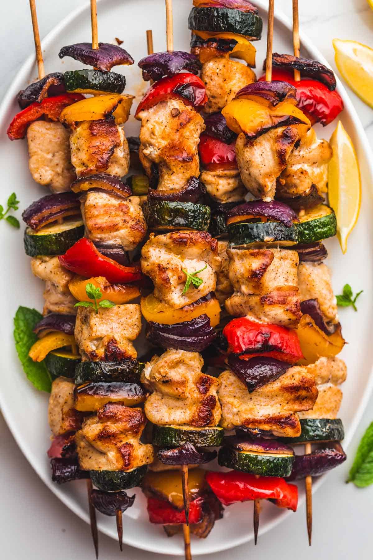 Grilled Chicken Kabobs stacked on an oval serving plate