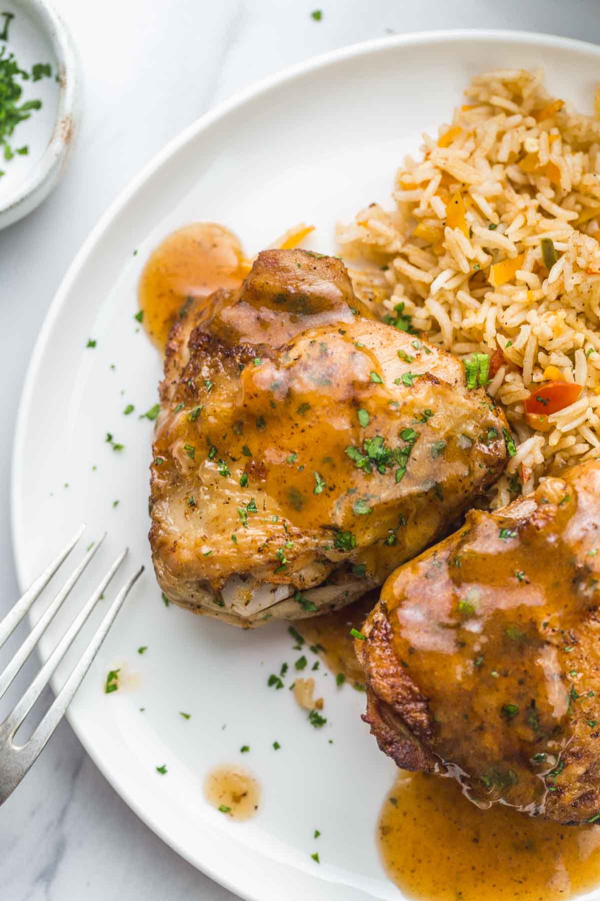 Chicken thighs served with rice, and gravy.