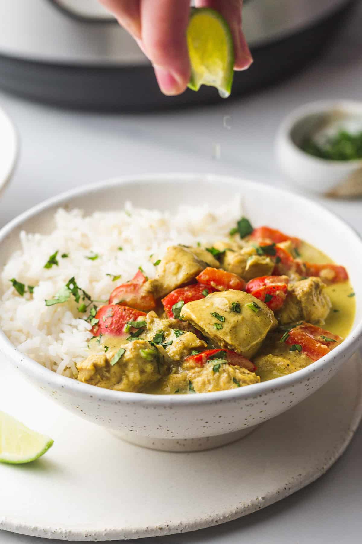 Squeezing a lime over coconut curry chicken