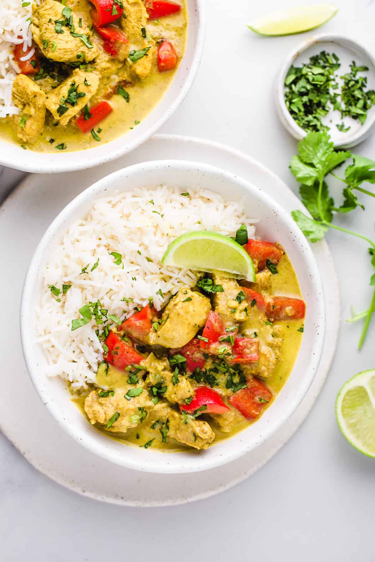 A flatlay of 2 bowls of coconut curry chicken