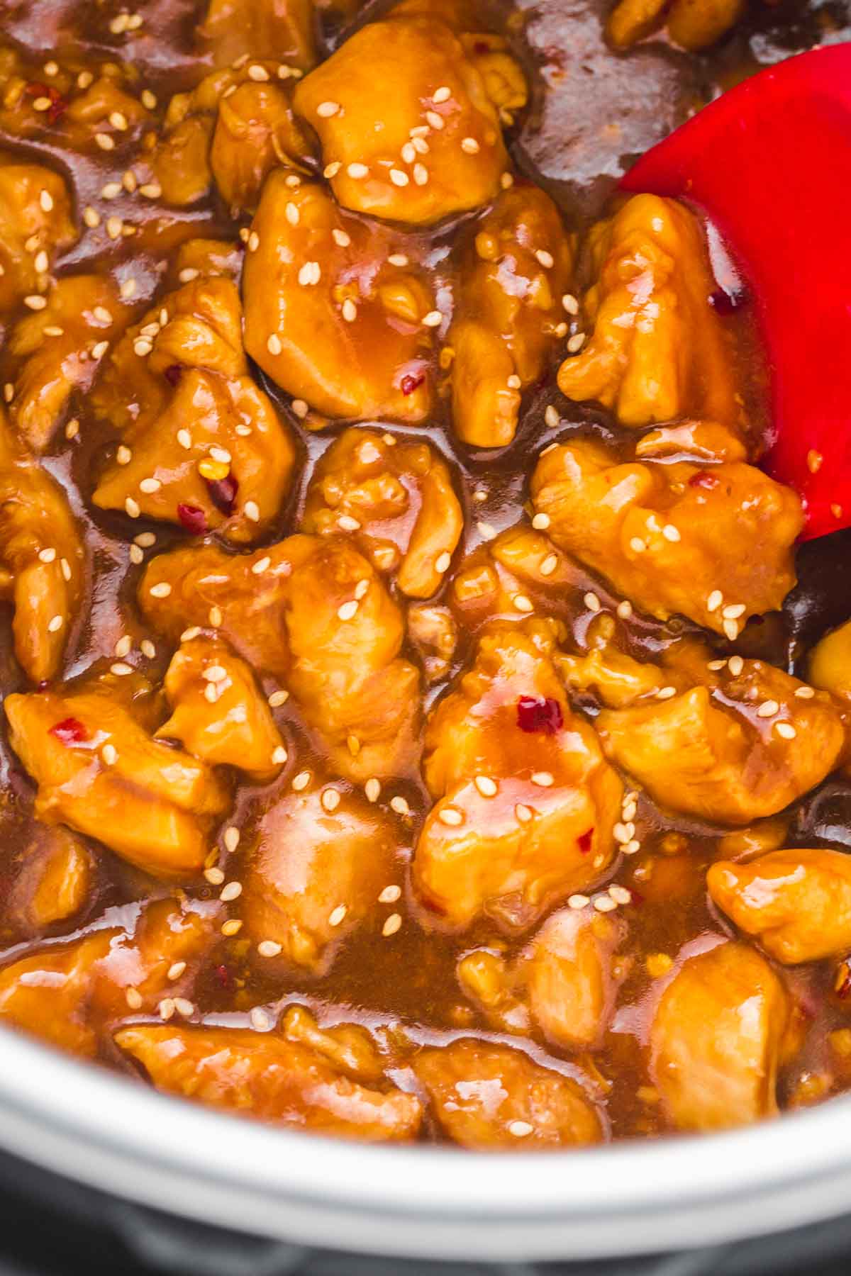 A close up shot of General Tso chicken in the Instant Pot, garnished with sesame seeds