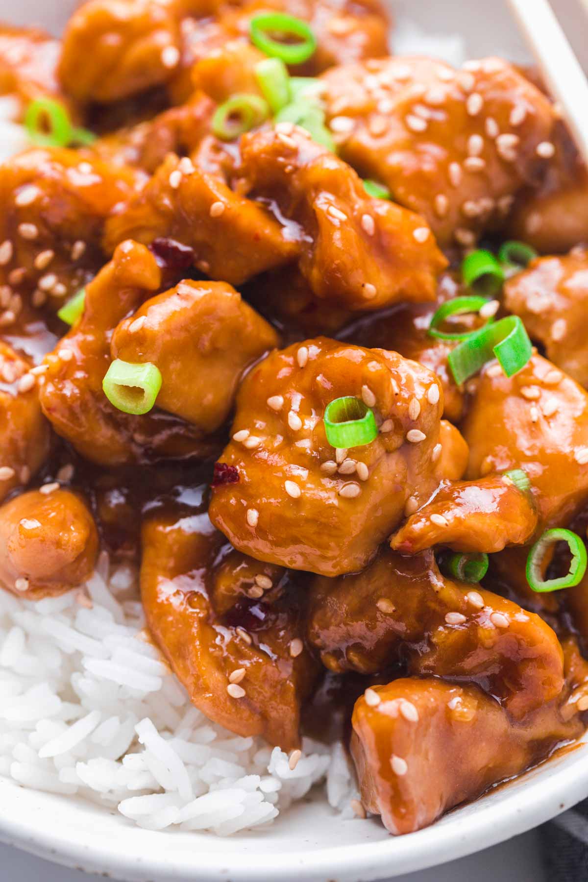 A close up of General Tso chicken on a bed of white jasmine rice