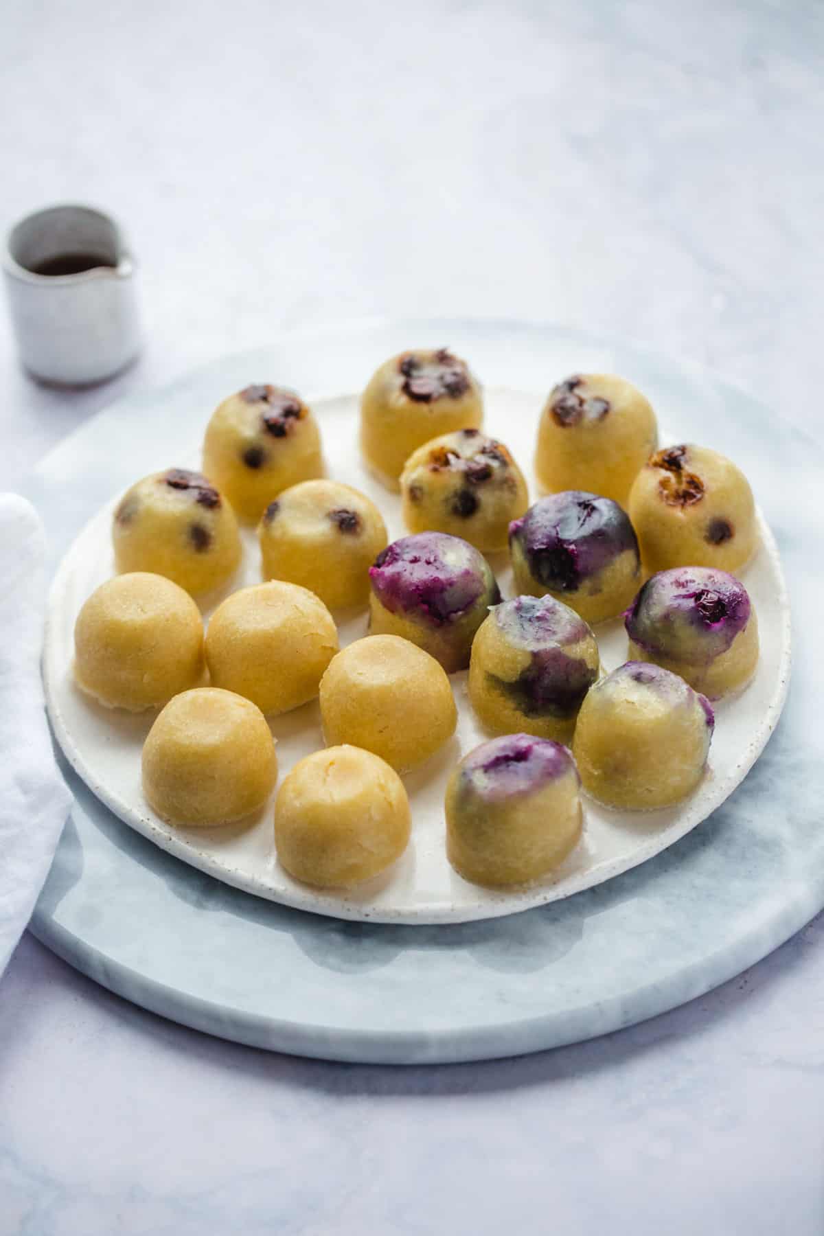 3 batches of pancake bites on a round light marble board