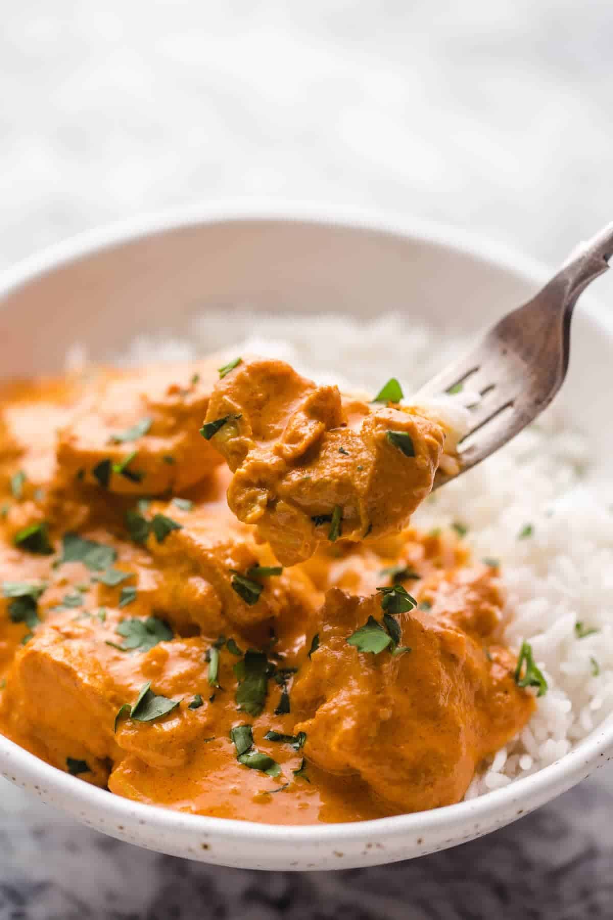 Eating butter chicken with a fork.