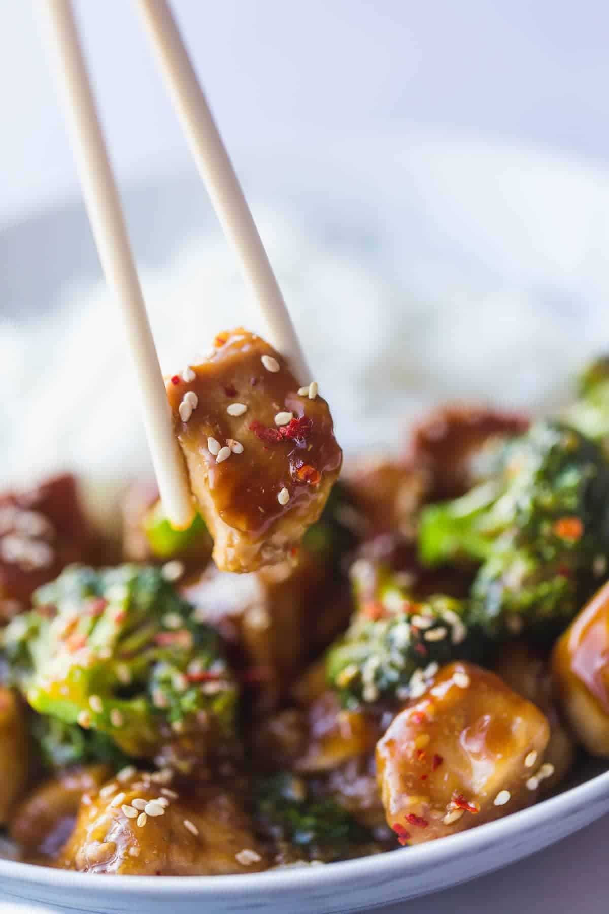 Instant Pot Chinese Chicken and broccoli with chop sticks picking up a piece of chicken