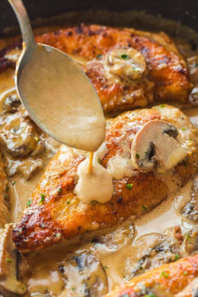 Instant Pot Marsala Chicken breast in the Instant Pot with creamy sauce being poured over it with a spoon