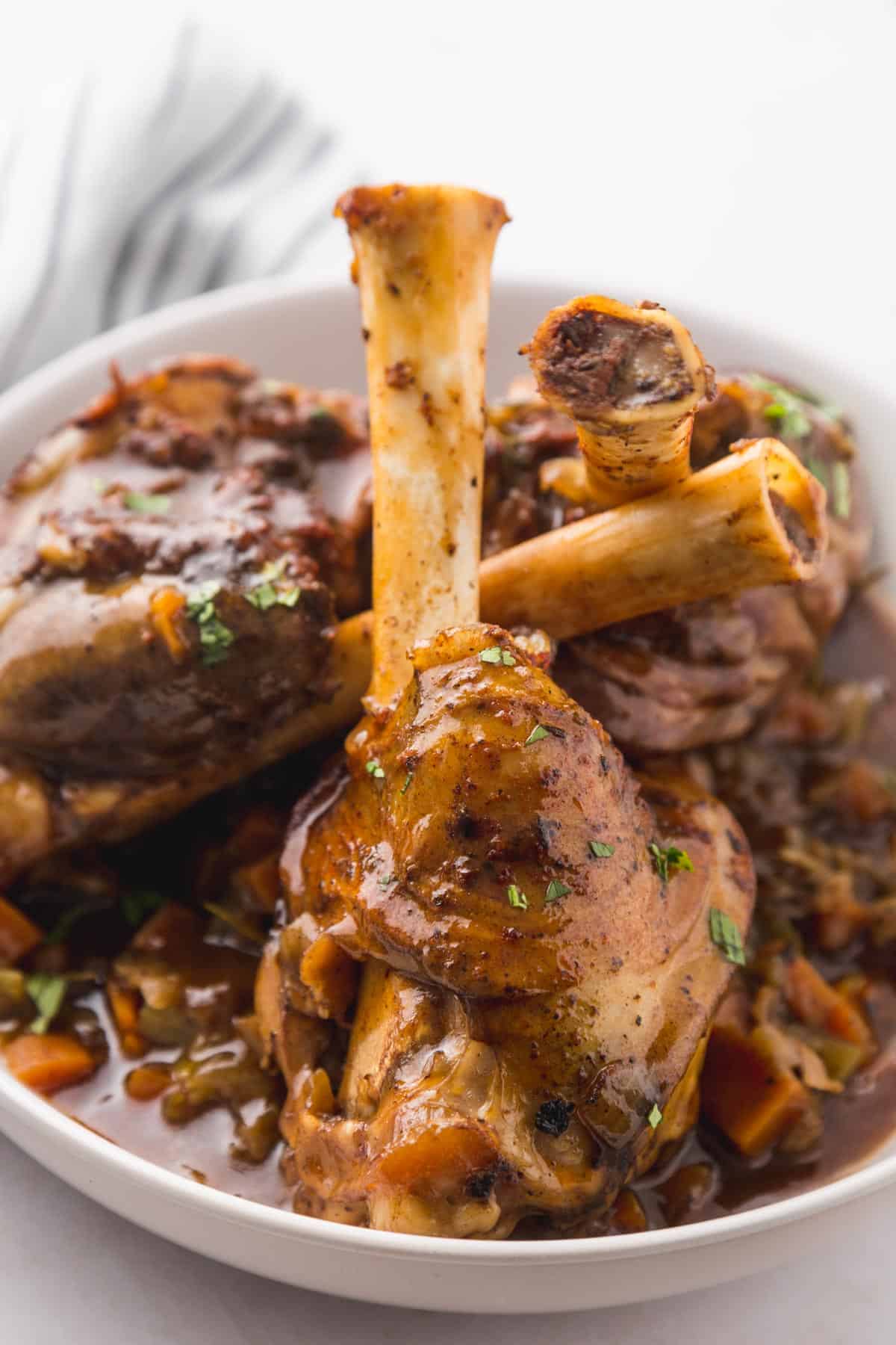 3 cooked lamb shanks in a plate