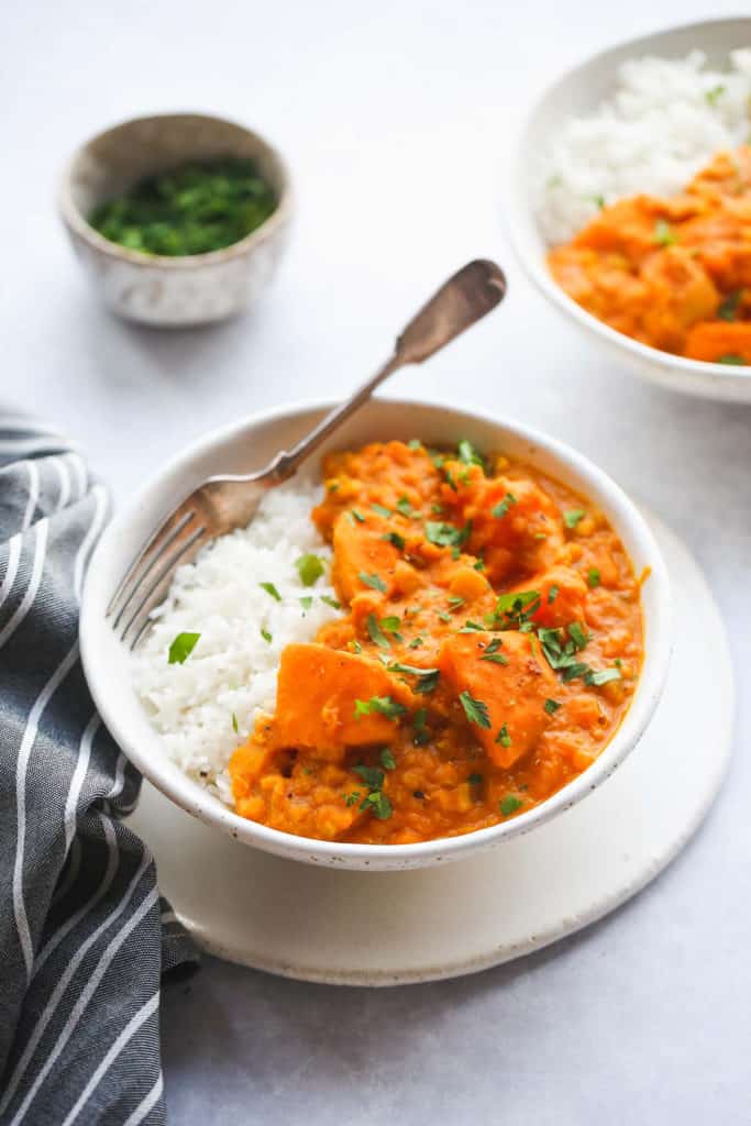 A white bowl of the instant pot pumpkin curry served over white rice