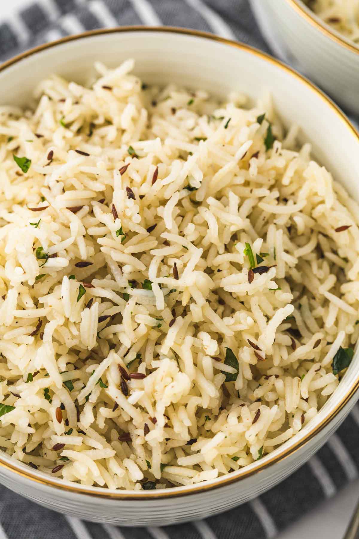 A close up of cumin rice in a white bowl