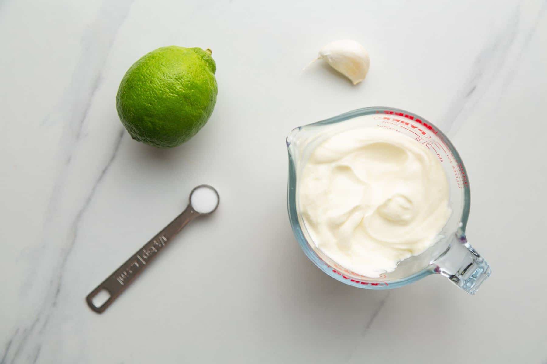 Lime Crema ingredients, sour cream, lime, garlic, and salt.