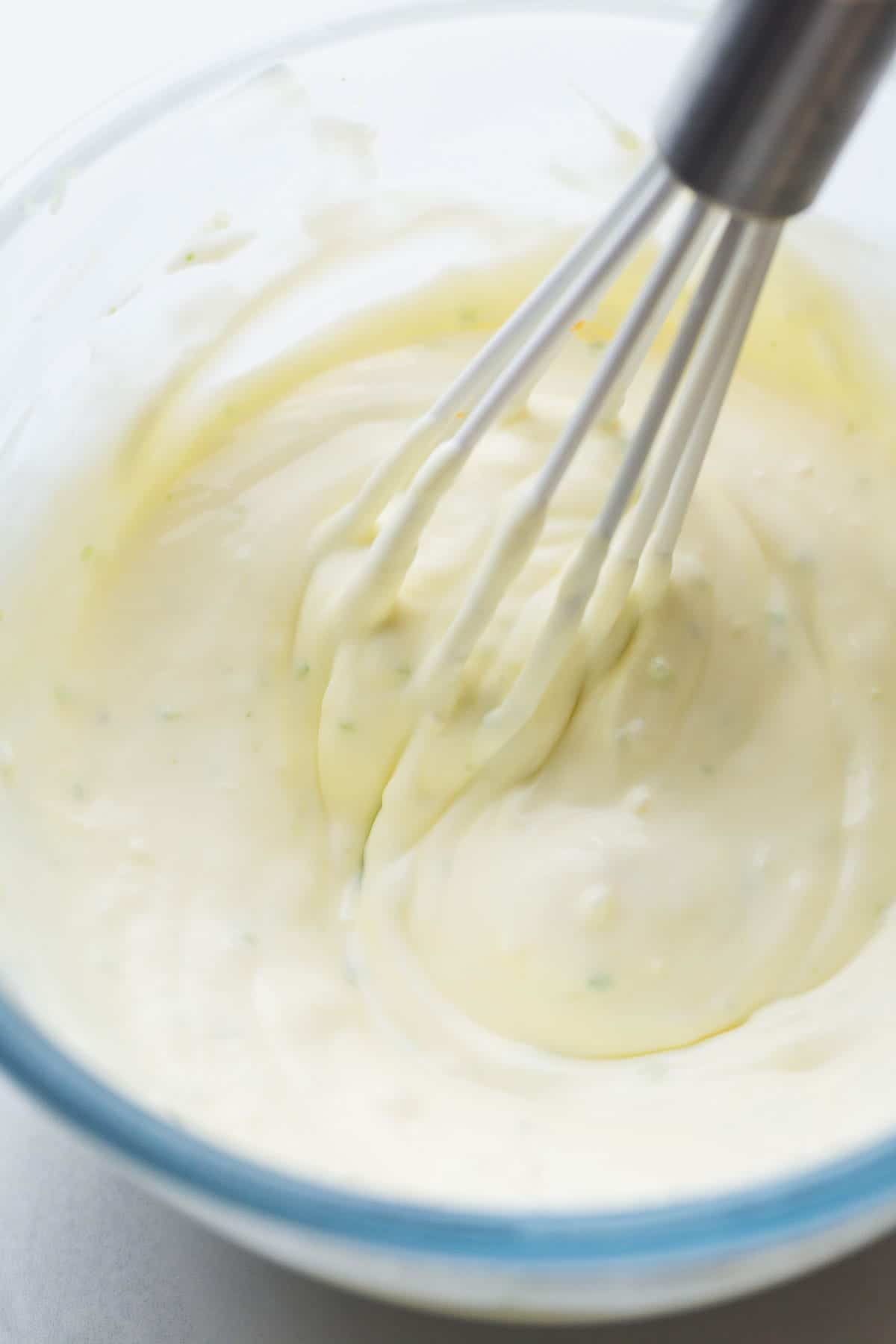 Whisking Lime Crema in a glass bowl using a small hand whisk