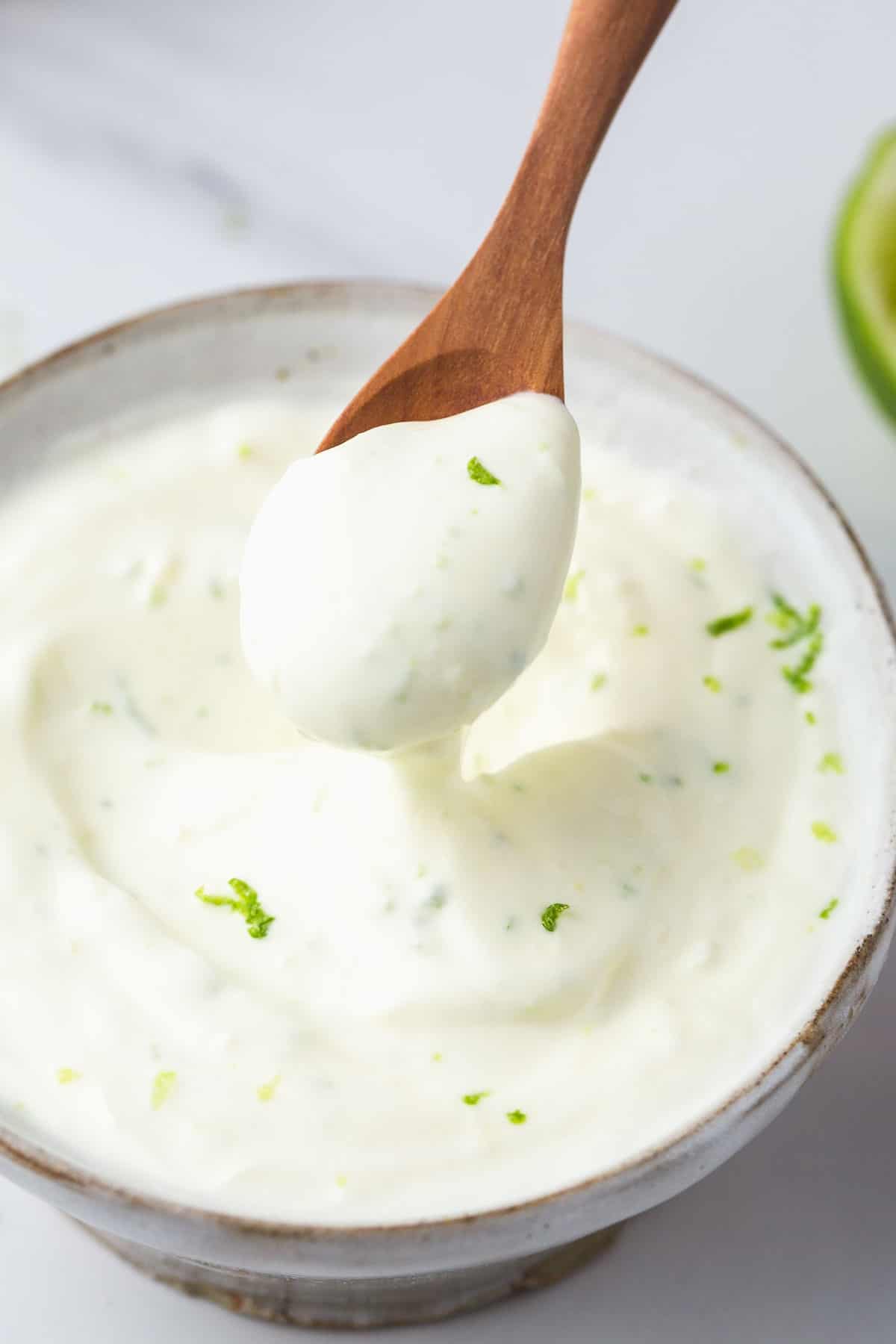 Lime Crema in a small bowl, with a wooden tea spoon