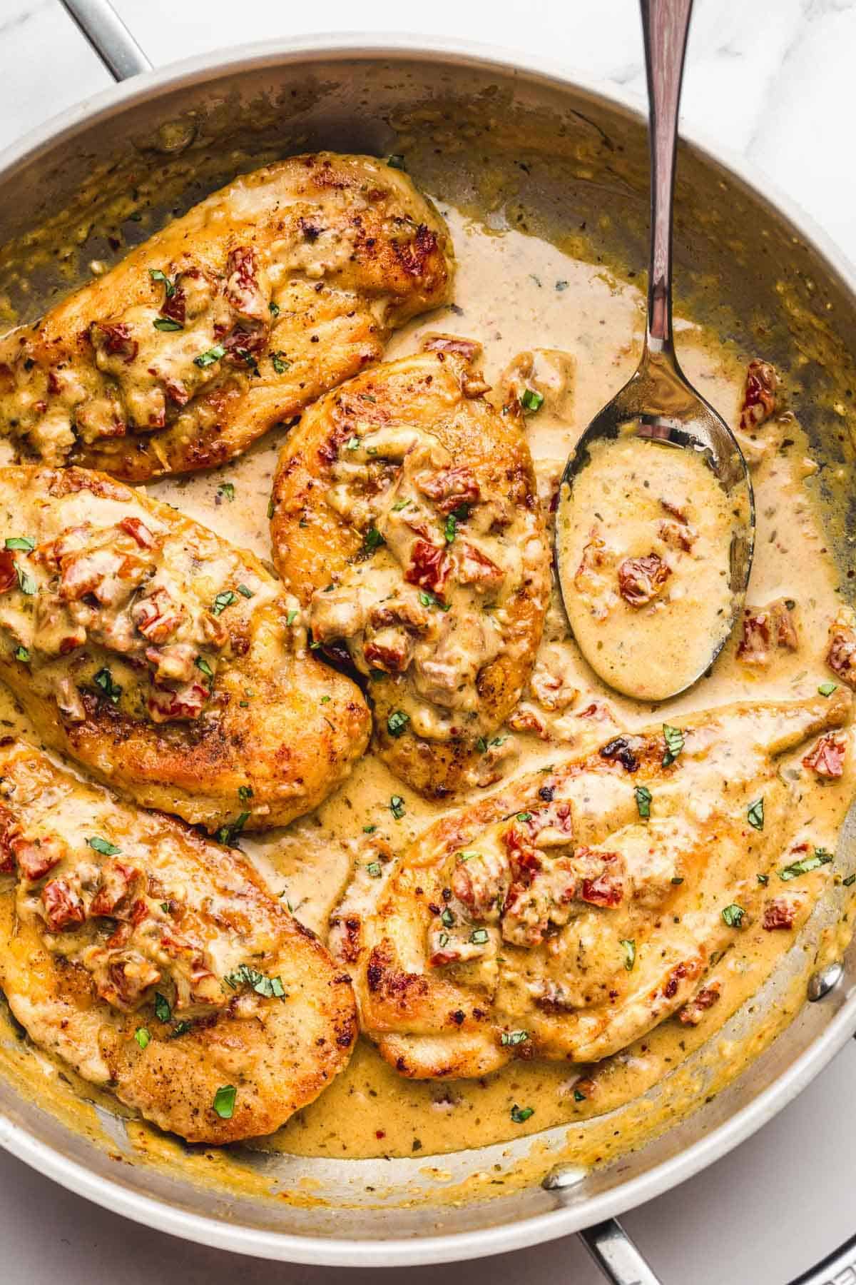 Creamy Marry Me Chicken in a stainless steel skillet, with a serving spoon