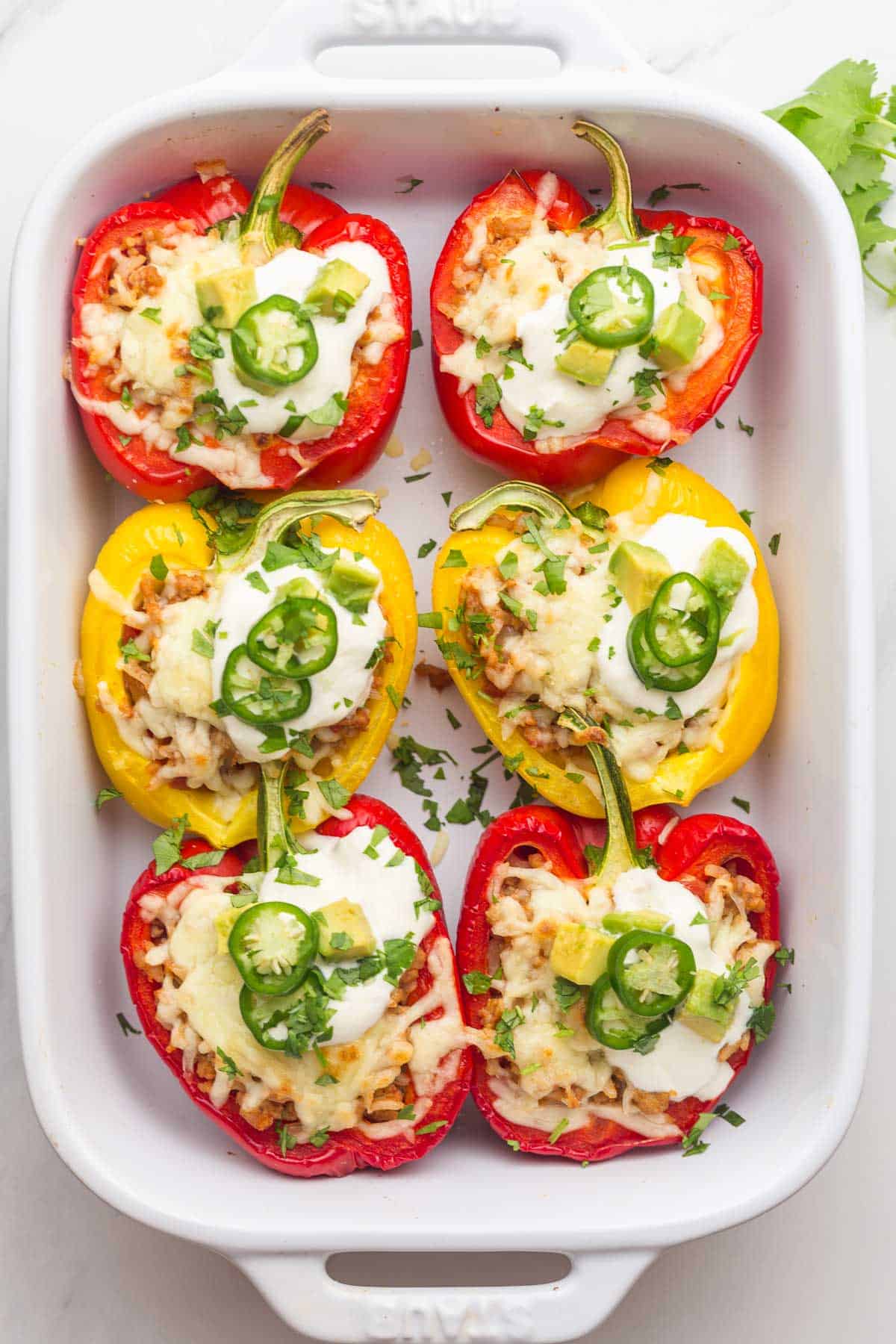 6 Mexican stuffed peppers in a white Staub baking dish