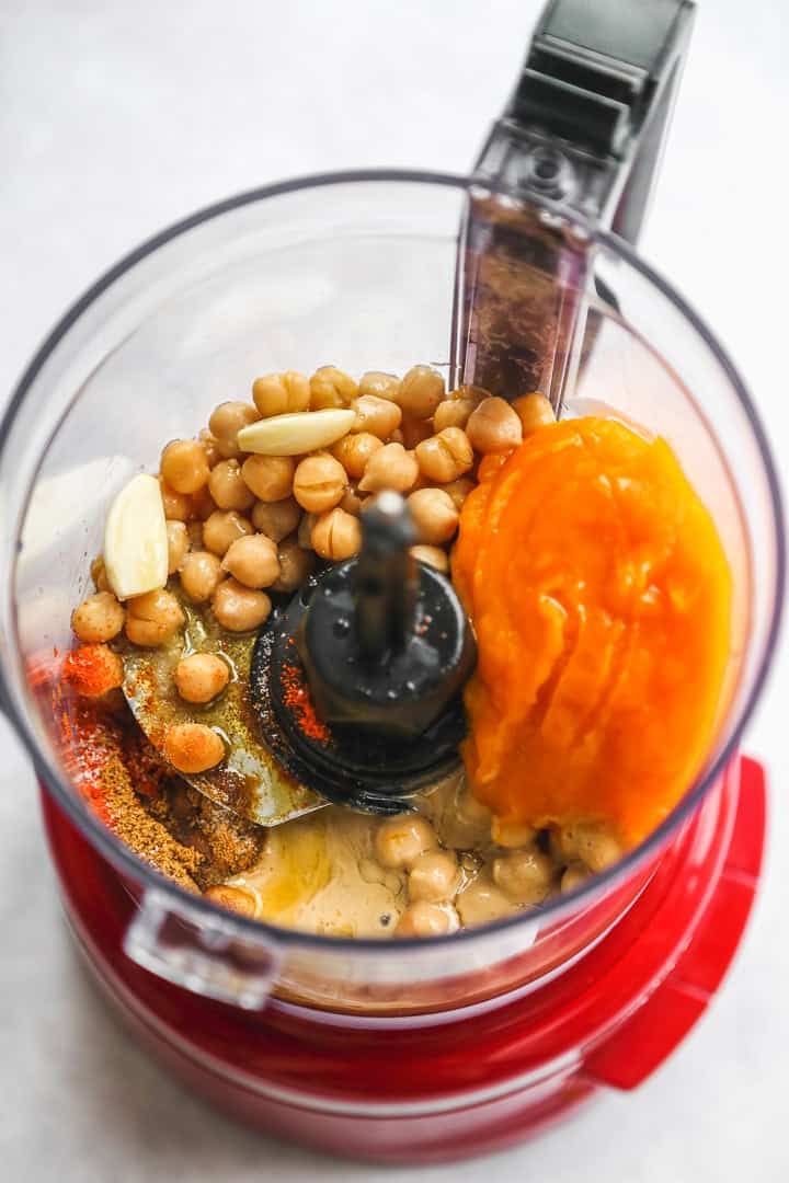 The pumpkin hummus ingredients in a KitchenAid food processor