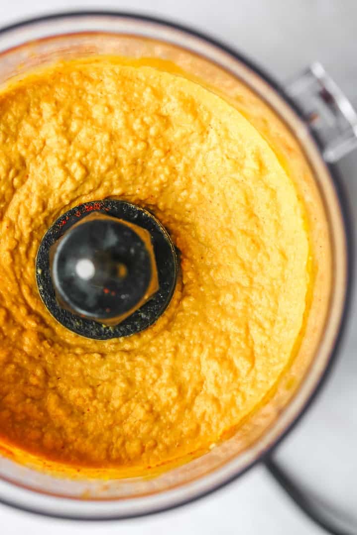 A close up of pumpkin hummus ready in a food processor