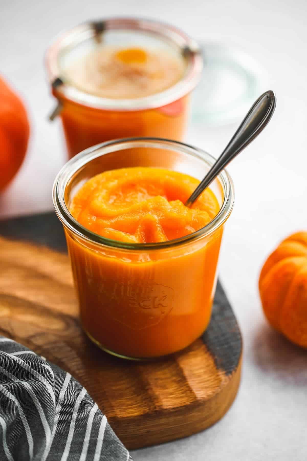 A weck jar with pumpkin puree and metal spoon