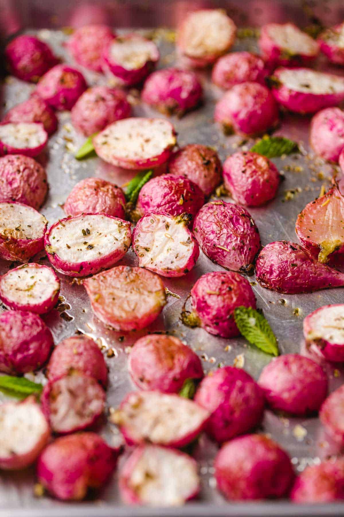 Roasted radishes on a sheet pan with mint leaves