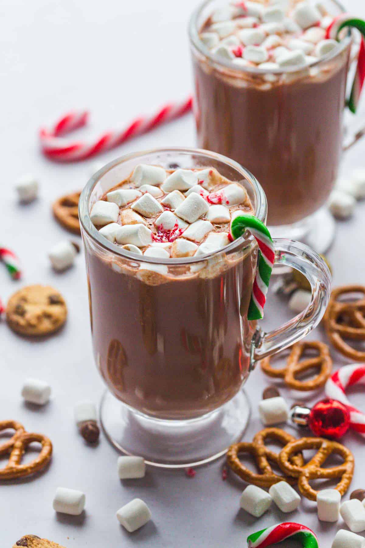 Slow Cooker Hot Chocolate in 2 mugs, topped with marshmallows and candy cane