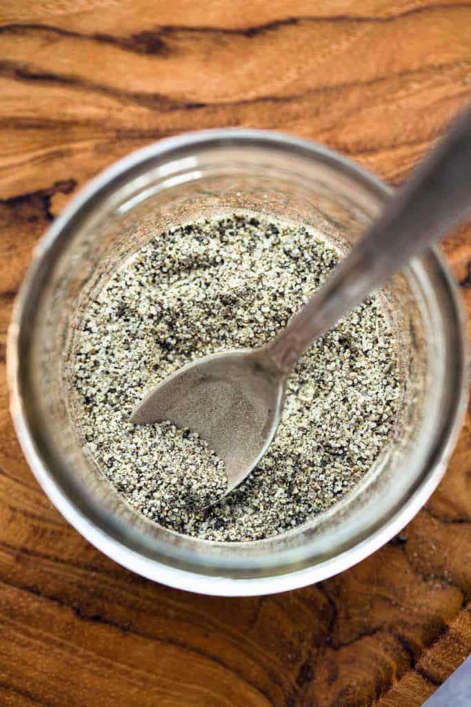 A close up shot of Stone House Seasoning in a jar with a spoon