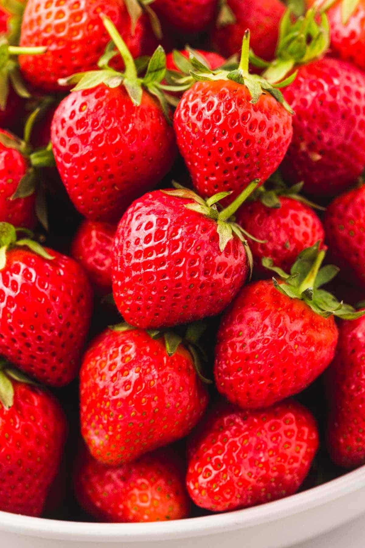 Close up of strawberries piled up in a white bowl