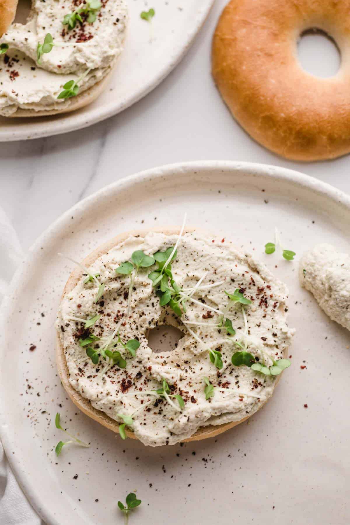 Cream cheese on a bagel with water cress, and sumac