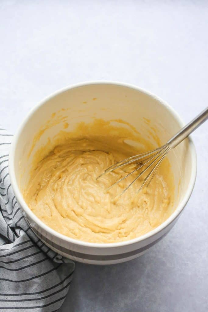Whisking the cornbread batter in a mixing bowl