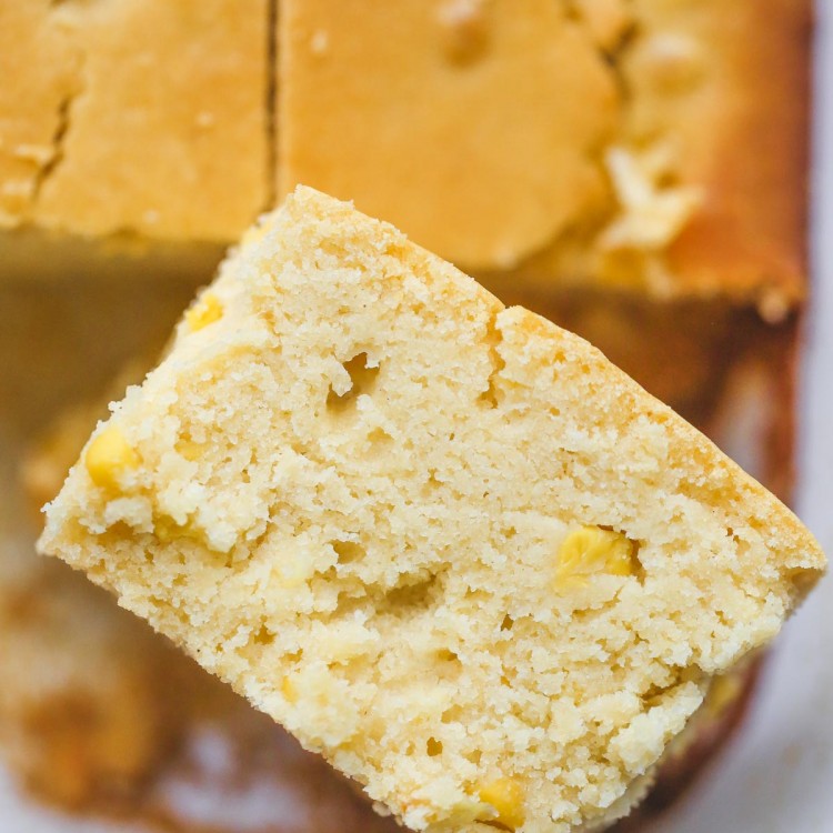 A close up picture of a slice of cornbread with corn kernels