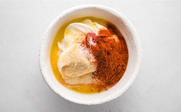 A bowl of mayo and spices in a white bowl.