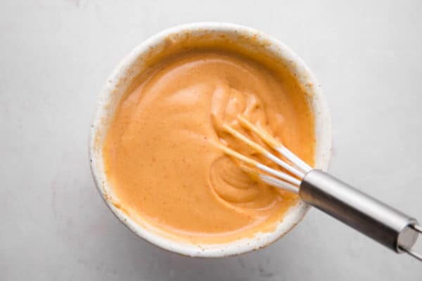 yum yum sauce in a bowl with a small whisk